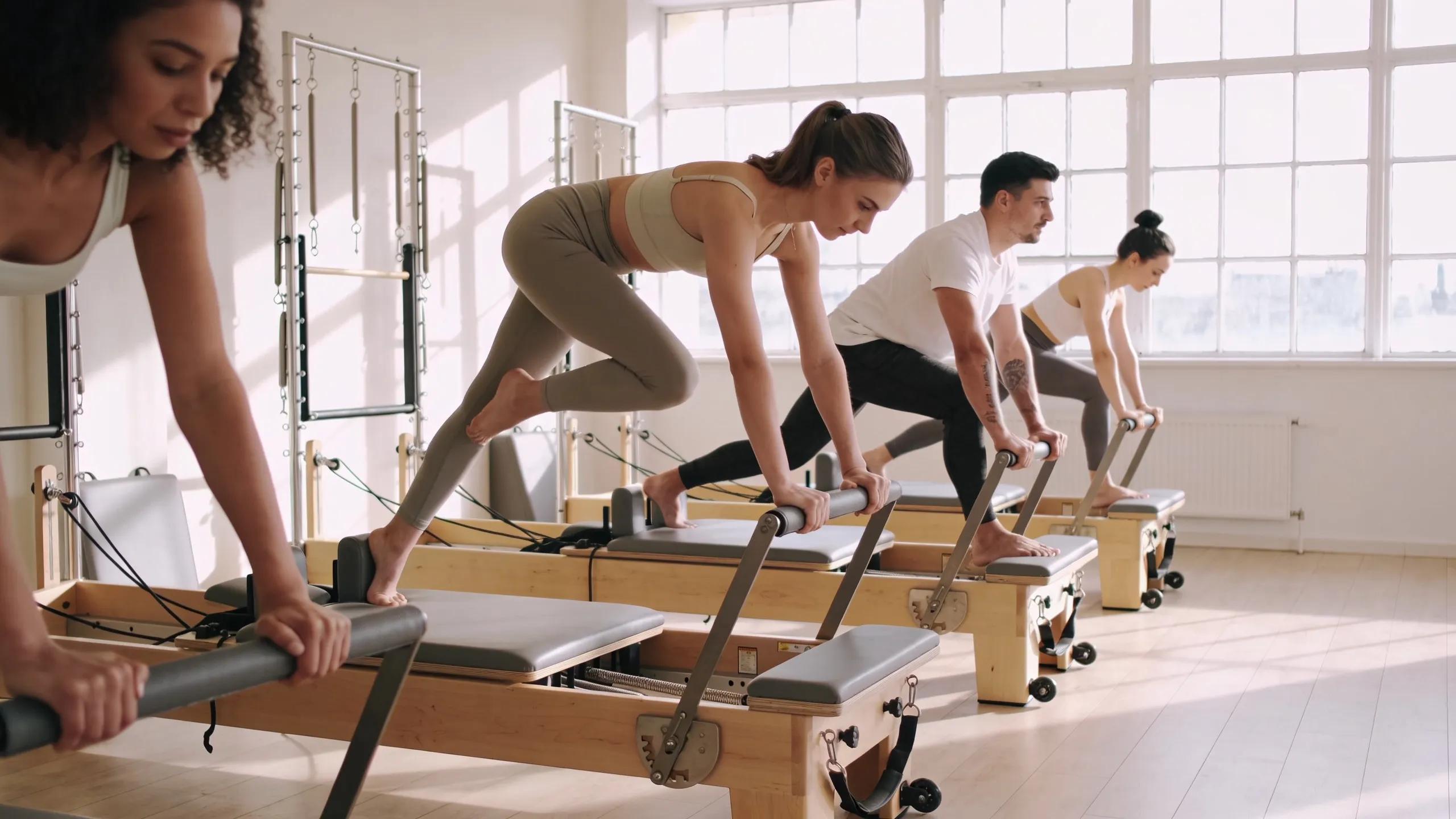 Group of individuals practicing Reformer Pilates in a bright studio, emphasizing health benefits and a supportive atmosphere